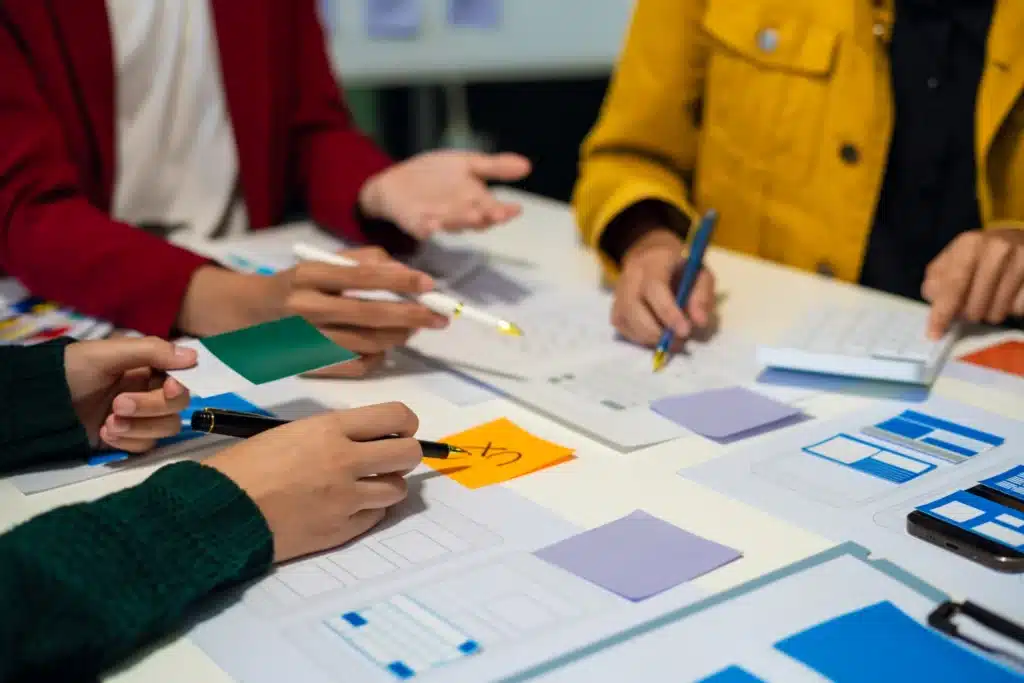 Personas colaborando en el diseño de interfaces de usuario (UX/UI) durante una sesión de trabajo en equipo en una Marketing Digital en Guarenas.